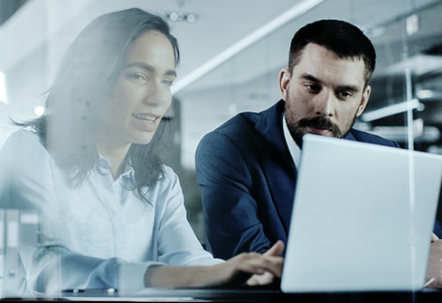 man and woman working at laptop